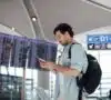 Hombre en el aeropuerto conectándose a una red wifi pública