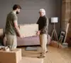 Padre ayudando a su hijo a hacer la mudanza a un piso, después de hacer un contrato de comodato