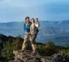 Una pareja feliz alcanzando la cima de una montaña, haciendo planes sin gastar dinero